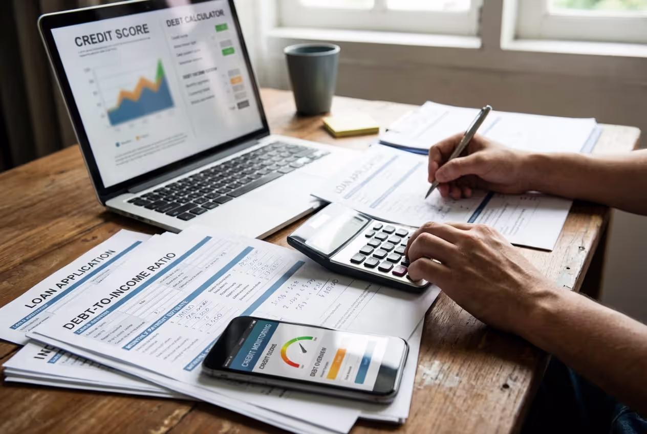 Desk with mortgage paperwork, calculator, and financial planning tools